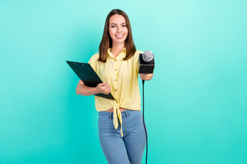 Photo of optimistic millennial brunette lady take interview give mic wear yellow top jeans isolated...