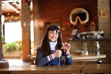 girl resting and drinking hot tasty mulled wine in a cafe ski resort