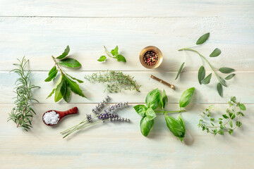 Fresh aromatic herbs, overhead flat lay shot on a wooden background with salt and pepper. Rosemary, lavender, bay leaf, thyme, basil, sage etc