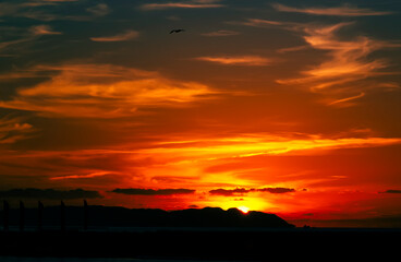 Precioso e impactante amanecer. Salida del sol en puerto deportivo. Amanecer y cielos impresionantes en la playa. Cielo rojo y dorado al amanecer.
