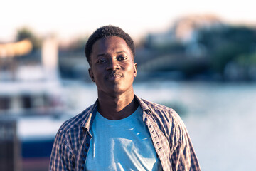 Fototapeta premium Portrait of an african young man smiling to the camera outdoors