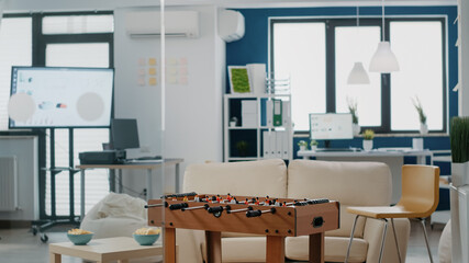 Nobody in business office with games to have fun after work. Empty workplace with chips, foosball...