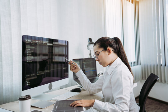 Software developers are analyzing about the code written into the program on the computer in office room.