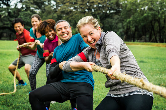 Team competing in tug of war - Powered by Adobe