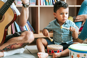 Little boy playing with a wooden drum set