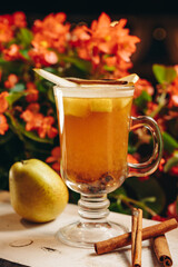 Hot drink cocktail for New Year, Christmas, winter or autumn holidays. Toddy. Mulled pear cider or spiced tea or grog with pear and cinnamon