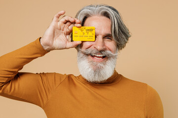 Elderly happy smiling gray-haired mustache bearded man 50s in mustard yellow turtleneck shirt hold...