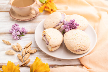 Meringues cakes with cup of coffee on a white wooden background. Side view.