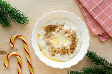 Christmas rice porridge with butter and cinnamon on wooden background, top view - obrazy, fototapety, plakaty