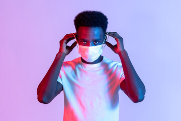 Young Black man preparing to put on a face mask