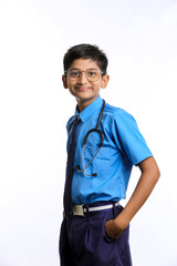 Indian little boy in school uniform playing with stethoscope isolated on white background
