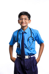 Indian little boy in school uniform playing with stethoscope isolated on white background