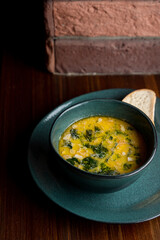 Bright yellow hot soup in a dark restaurant