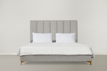 Fototapeta na wymiar Modern gray bed with padded headboard