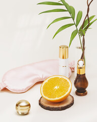 Spa relax composition with sleep mask, orange halfe and beauty product in cosmetic bottles. Orange, natural remedies for the treatment of depression, insomnia and nervous stress. Relaxing at home