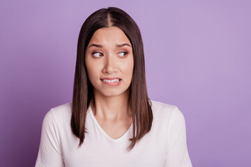 Photo of young woman unhappy sad upset negative moody bite lips teeth fail isolated over violet...