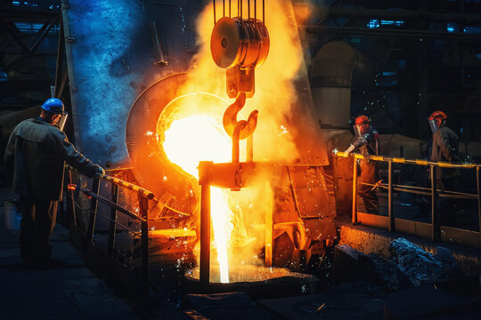 Process of casting in foundry, liquid molten metal pouring in ladle. Heavy metallurgy industry.