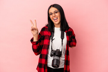 Young caucasian photography woman with one arm isolated on pink background joyful and carefree showing a peace symbol with fingers.
