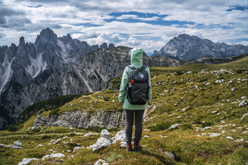 Naklejka premium Woman hiker with backpack against Cadini di Misurina mountain group range of Italian Alps, Dolomites, Italy, Europe