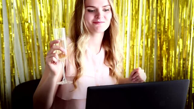 Woman on online Christmas corporate party or online bachelorette party with a laptop and champagne on the party background. Internet celebration concept