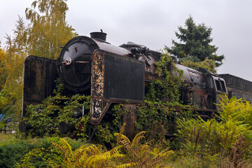 Abandoned `Berliner Maschinenbau AG` steam locomotive made in 1930 surrounded by grass, pictured on...