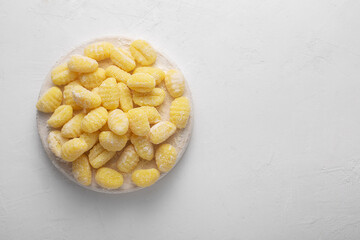 Raw italian gnocchi on a white background, top view