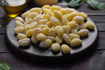 Raw italian gnocchi close up on a dark background prepared with potato and dough