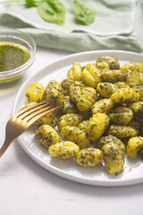 Traditional gnocchi with pesto sauce on gray concrete background. It usually prepared with potato and dough. Close up shot