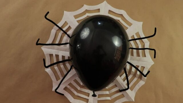 Halloween decorations. Black spider balloon and paper spiderweb.