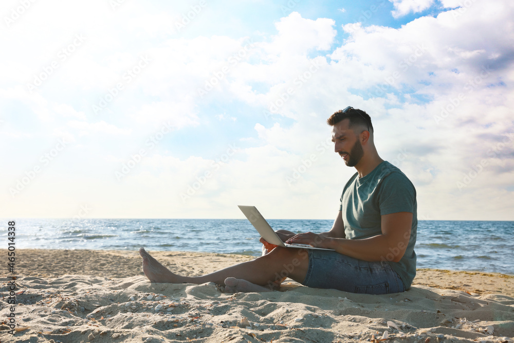 Sticker Man working with laptop on beach. Space for text