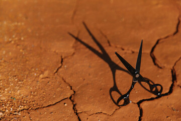 Scissors on cracked clay. Barber for men.