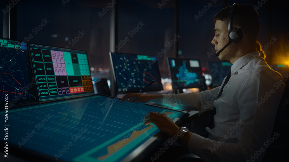 Wall mural male air traffic controller with headset talk on a call in airport tower. office room is full of des