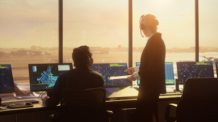 Diverse Air Traffic Control Team Working in Modern Airport Tower at Sunset. Controllers Celebrate the First Take Off of a New Commercial Aircraft with Clapping Hands in a Room Full of Computers.