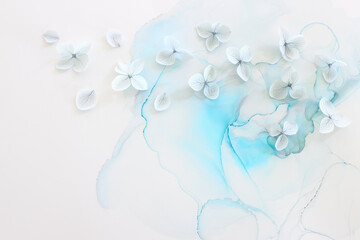 Fototapeta na wymiar Creative image of pastel blue Hydrangea flowers on artistic ink background. Top view with copy space