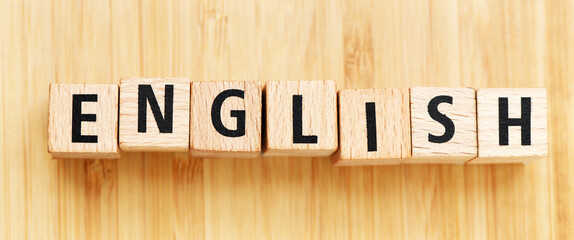 ENGLISH word arranged from wooden letters on wooden table.