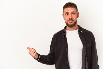 Young caucasian man with diastema isolated on white background shocked pointing with index fingers to a copy space.