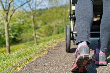 woman walking with baby stroller in nature