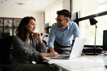 Colleagues in office. Businesswoman and businessman discussing work in office. Two friends working...