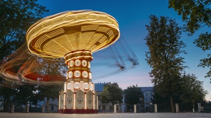 Fototapeta na wymiar Set. Brightly Illuminated Rotating High Speed Carousel Merry-Go-Round. Summer Evening Night In City Amusement Park. Attraction Ferris Wheel On Summer Evening In City Amusement Park