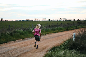 Obraz premium Long haired boy running on country road