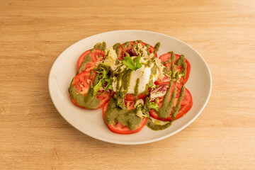burrata cheese salad with tomato slices and ratatouille sauce with lettuce and parsley