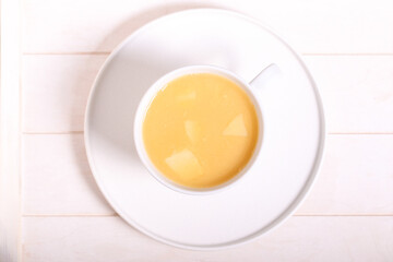 pea soup with crackers is on a white table