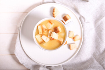 pea soup with crackers is on a white table
