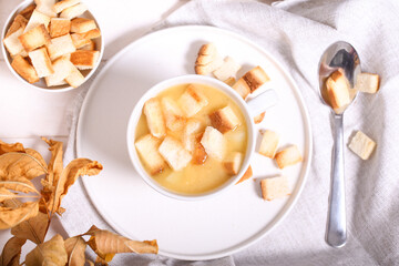 pea soup with crackers is on a white table