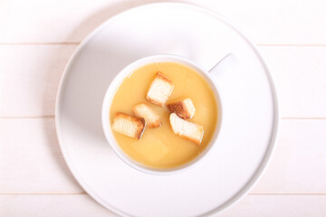 pea soup with crackers is on a white table