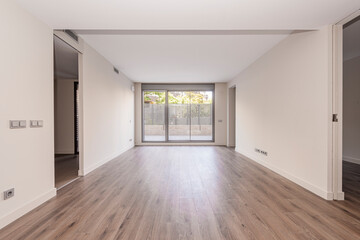 Fantastic terrace with large windows that join it to a bright living room in an empty apartment