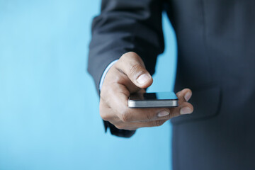 Close up of young man hand using smart phone.