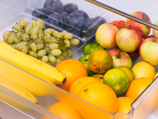 A fridge drawer full of fruits.