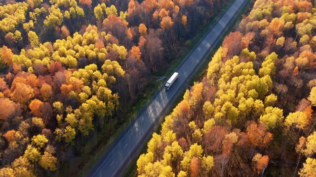 A long truck with a trailer catches up with a bright red fire truck. Driving on a suburban highway. The concept of compliance with safety measures on the road. High quality. 4k footage.