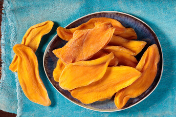 Top view of dried mango slices on a plate. Selective focus.